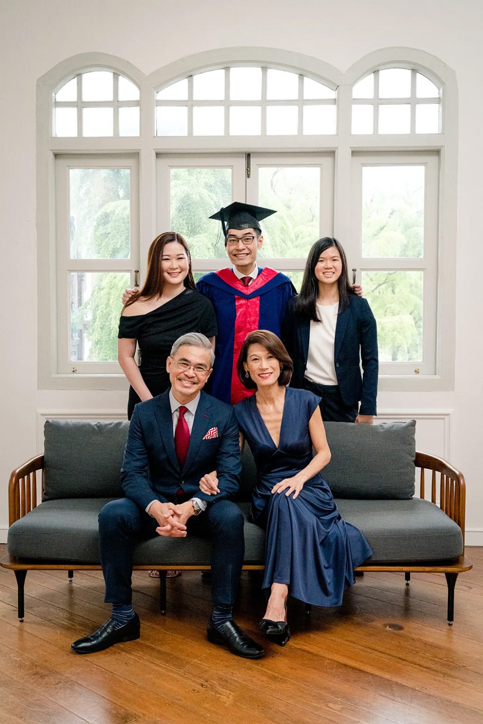 A family of five against a white wall and windows