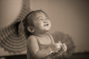 black and white photo of baby eating cake