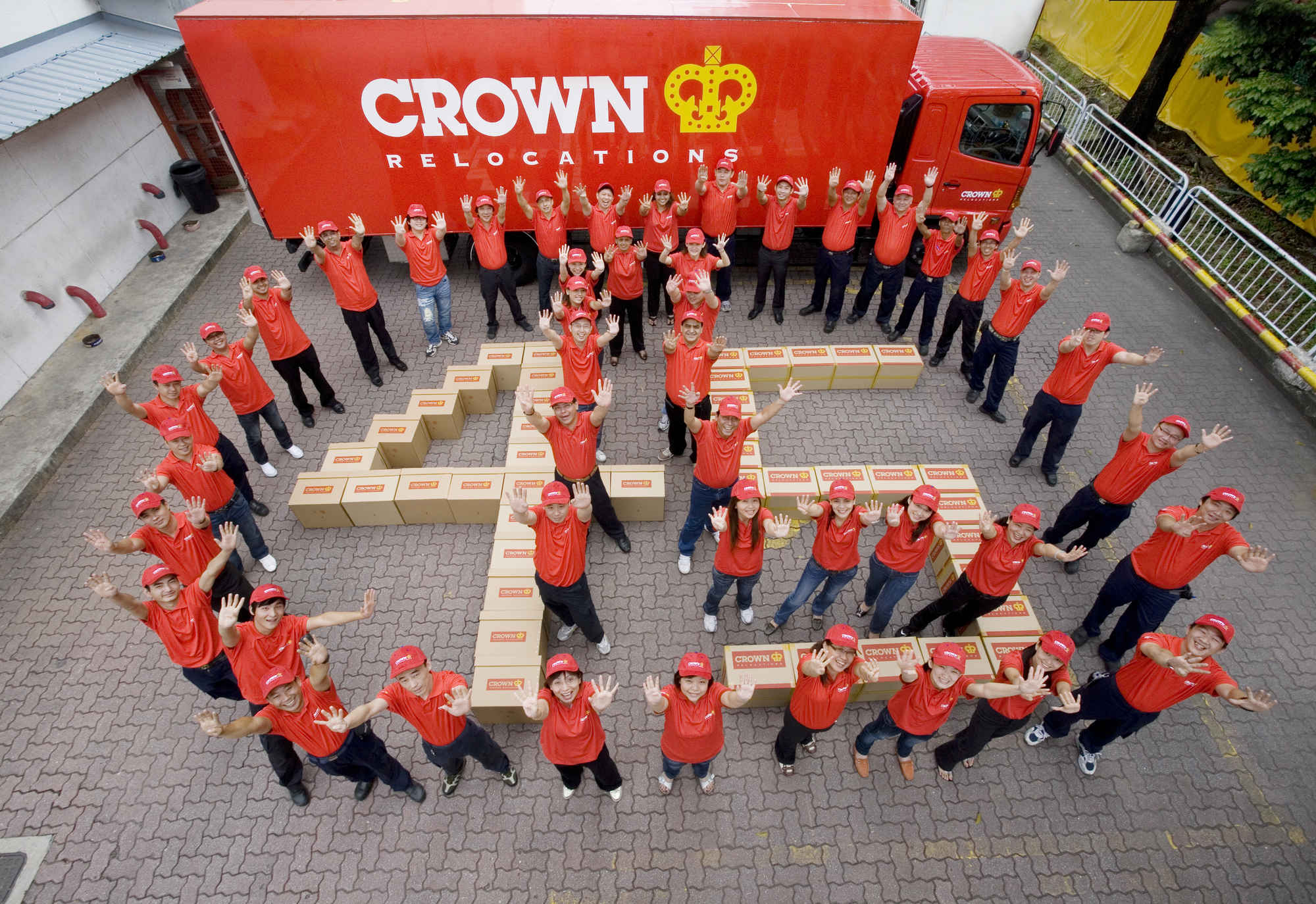 Employees of Crown International dressed in company uniform posing for a company photo during professional outdoors photoshoot in Singapore