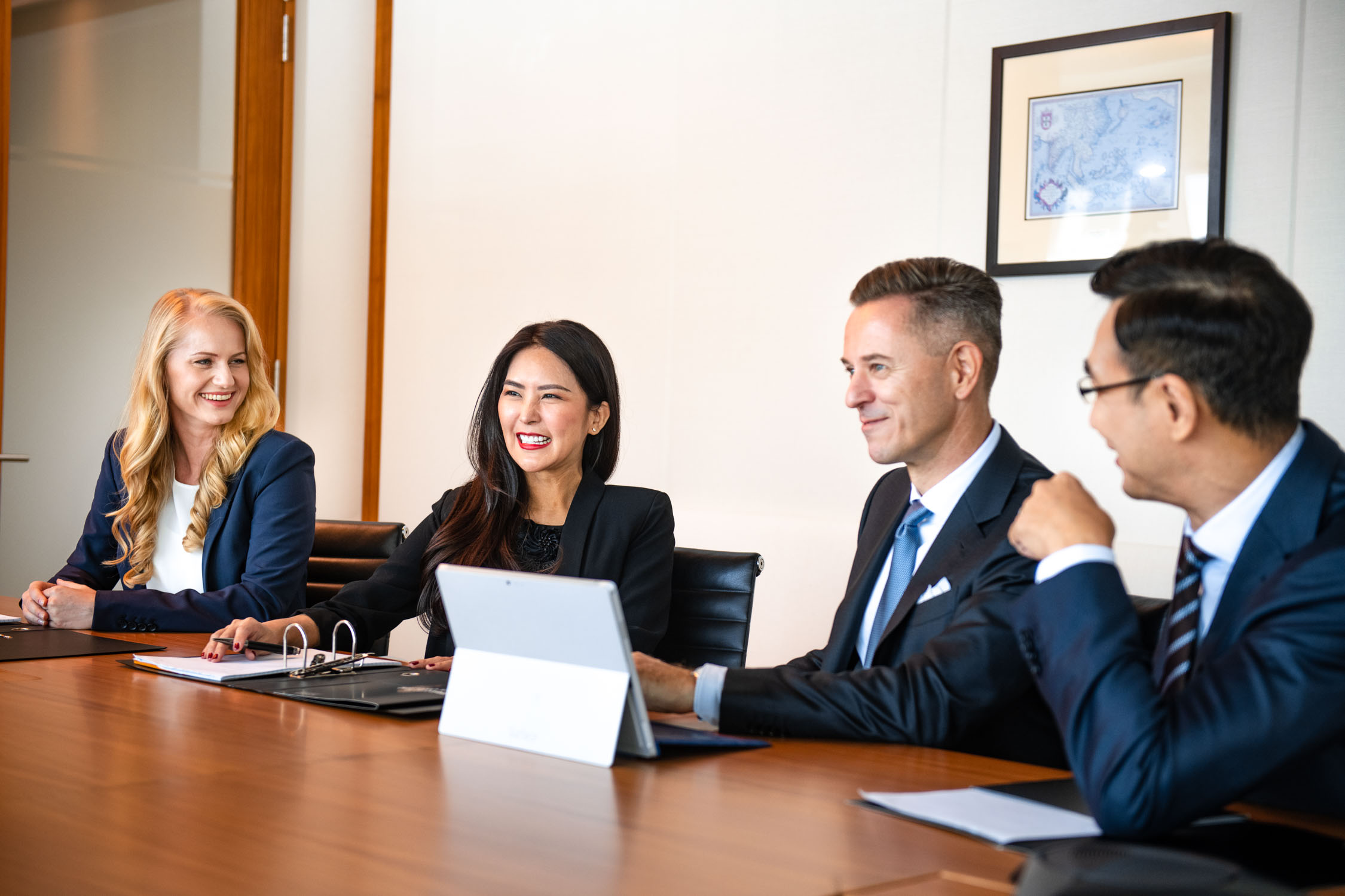 A group of corporate professionals (two women and two men) sitting down having a meeting in the office