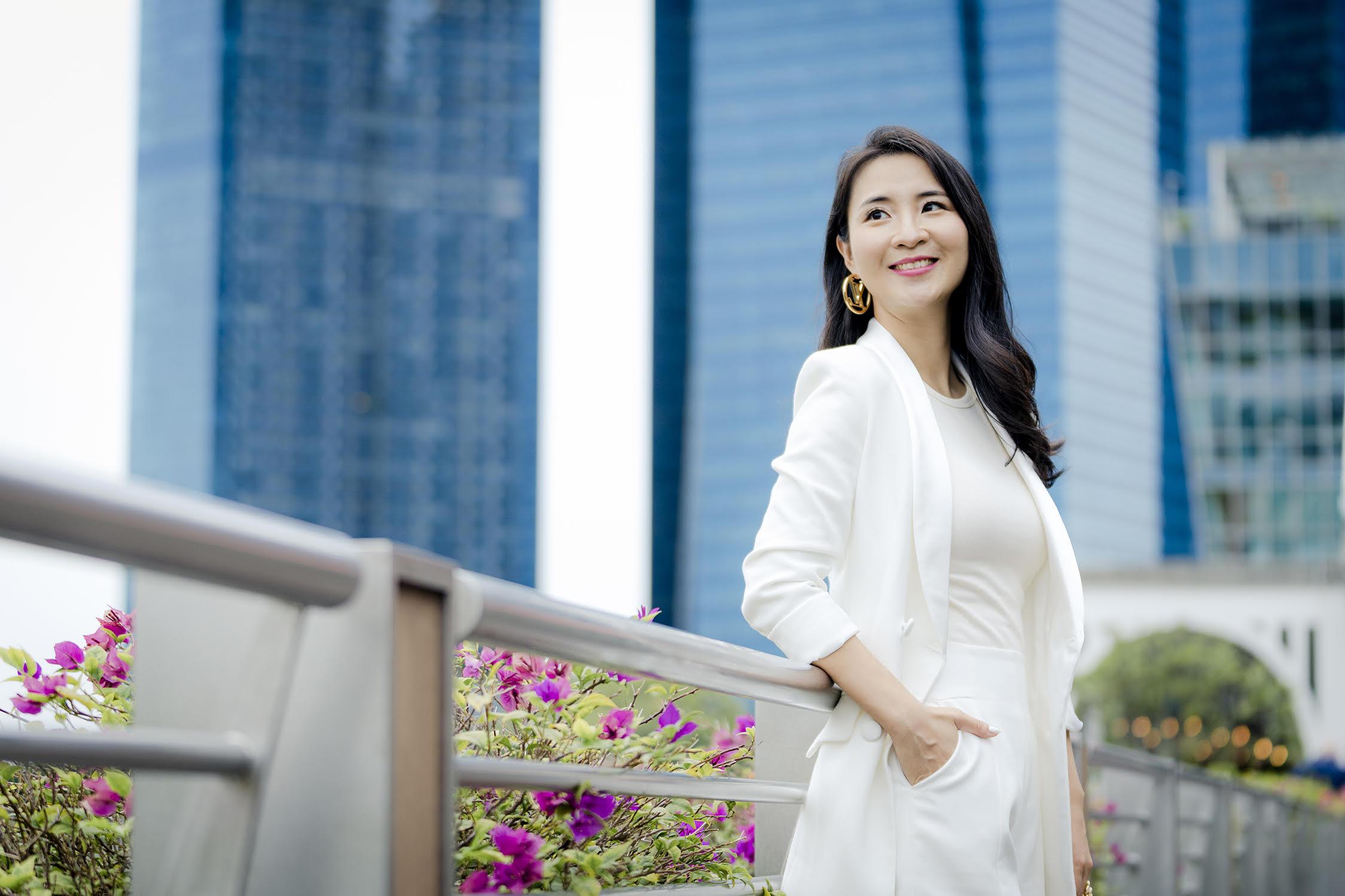 Woman in a white blazer and top poses for her personal branding headshot in Singapore