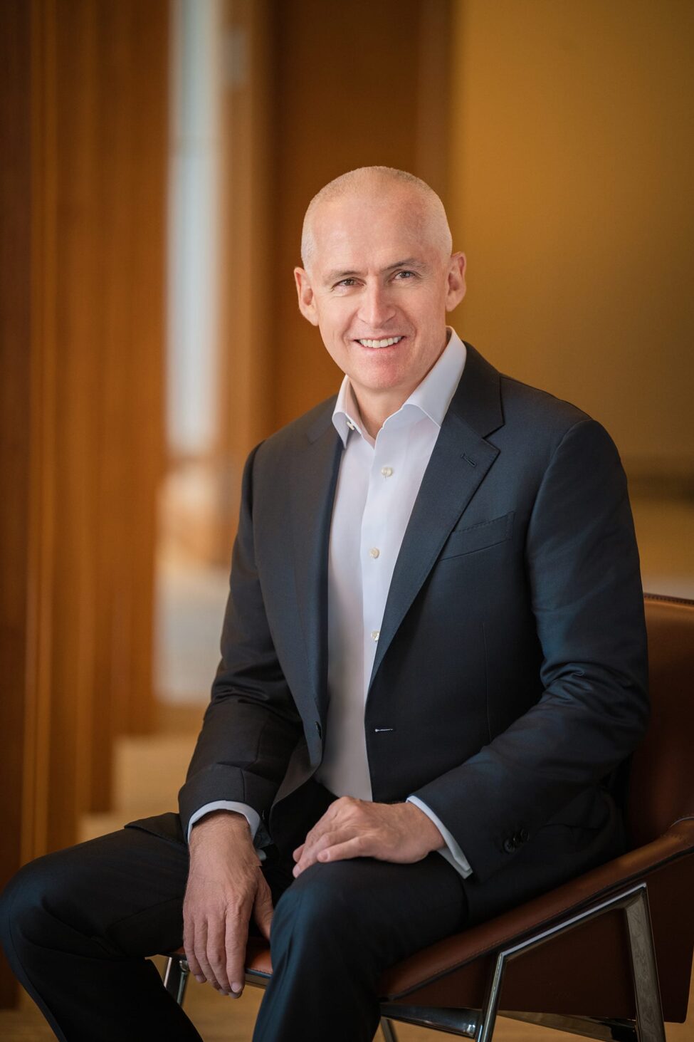 Man in professional black and white suit smiling for headshot in a photography studio setting during a corporate photoshoot in Singapore, White Room Studio. Credit: White Room Studio Pte Ltd