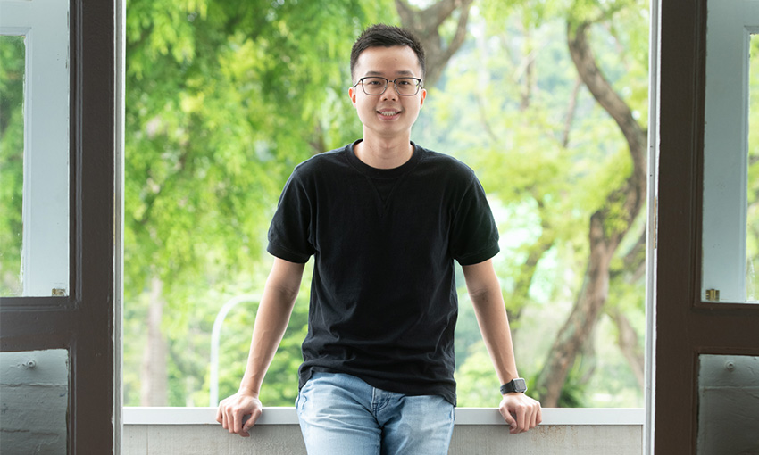 Man smiling while standing in a balcony surrounded by nature and greenery by White Room Studio during a portrait photoshoot in Singapore, White Room Studio. Credit: White Room Studio Pte Ltd