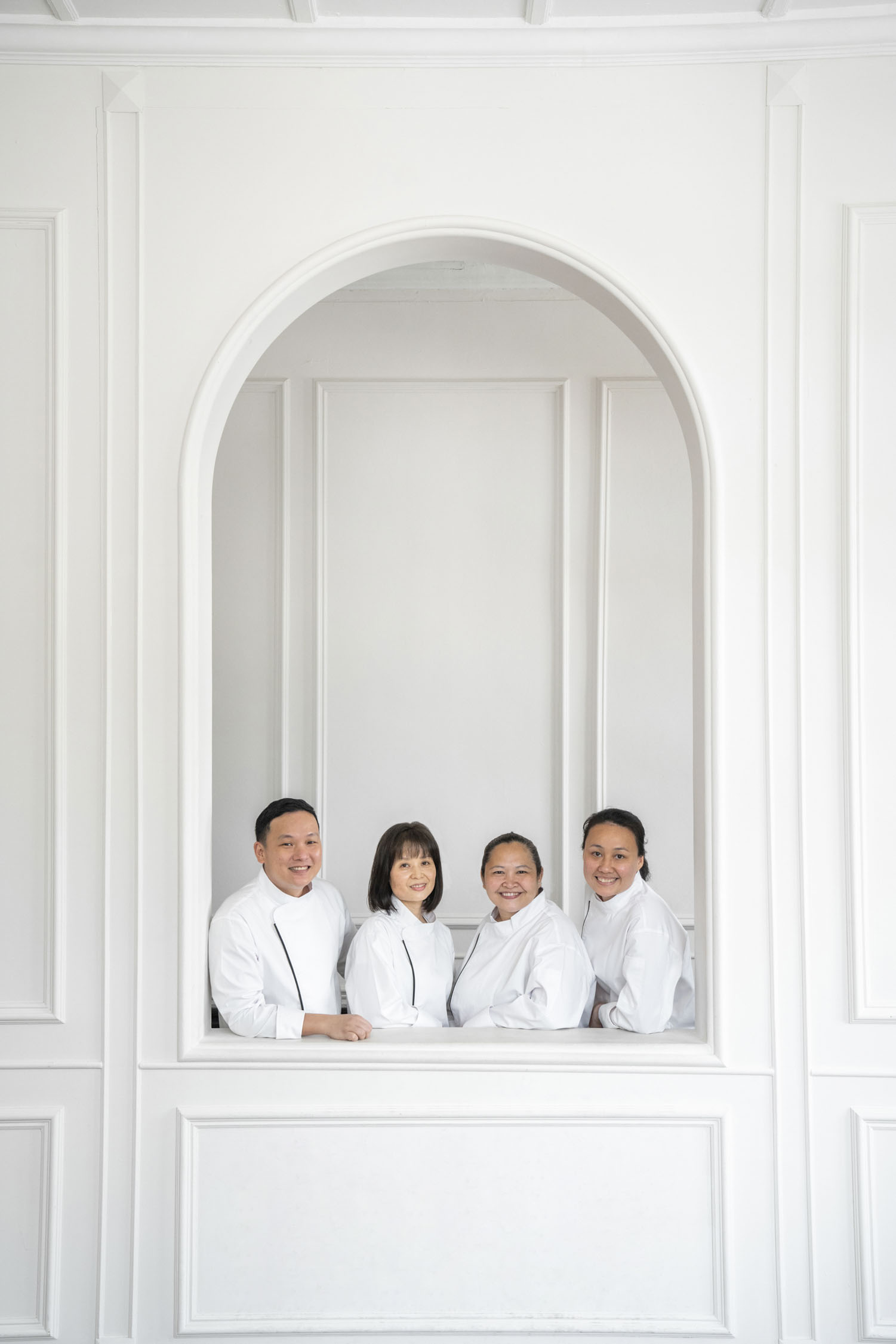 Professional bakers in chef uniforms smiling in a photography studio setting during a corporate photoshoot in Singapore, White Room Studio. Credit: White Room Studio Pte Ltd