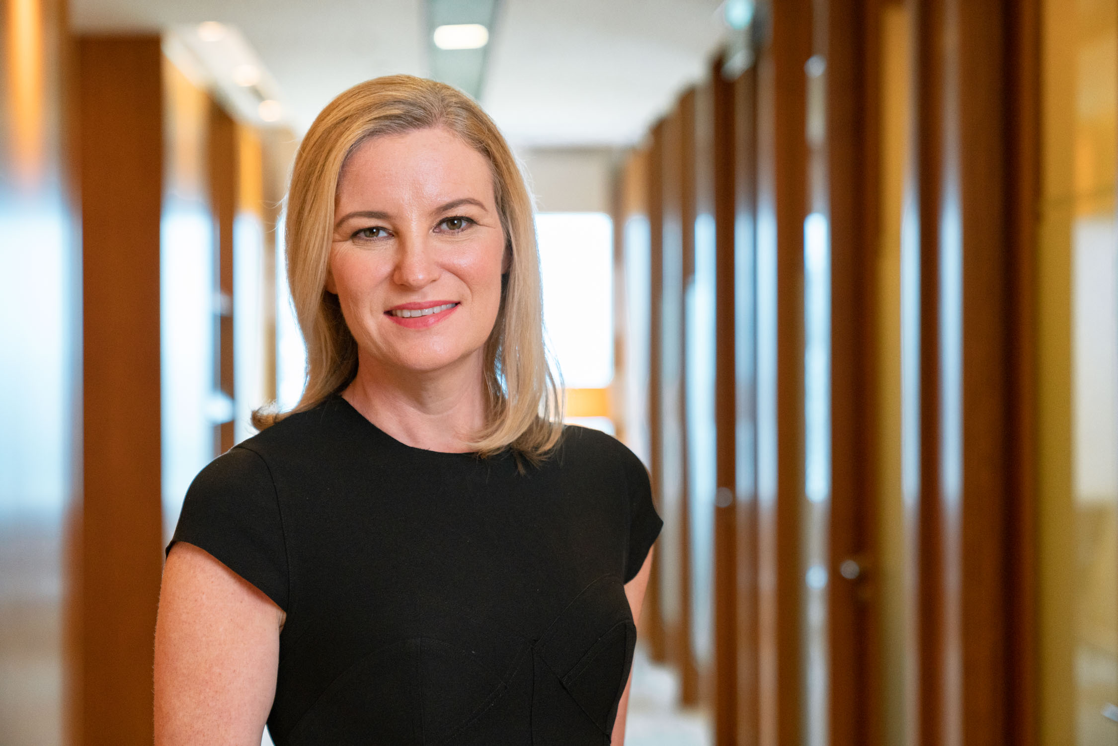 Woman with blonde hair in a black dress posing for her headshot during a professional corporate photoshoot in Singapore