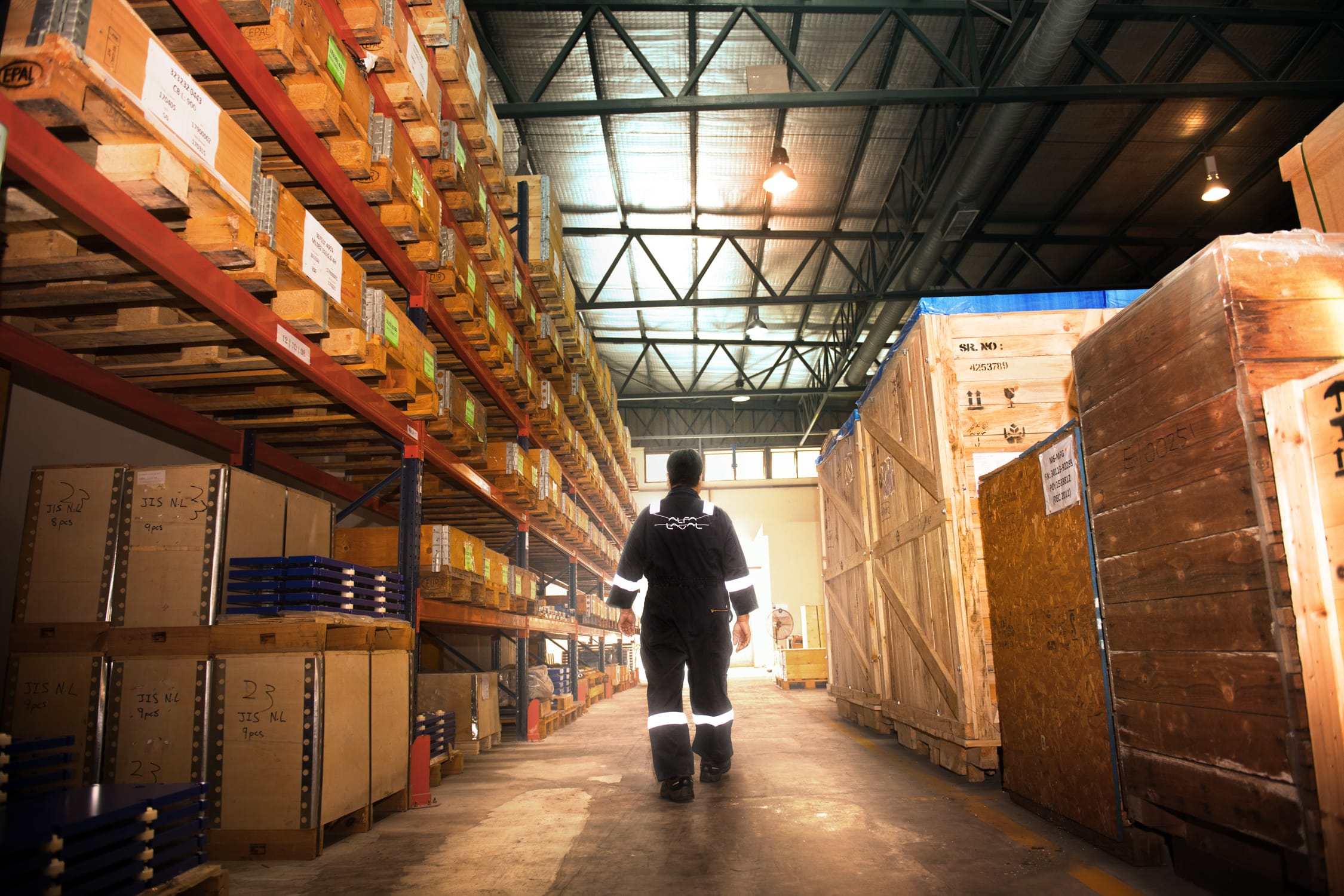 A man in a blue jumpsuit walks down the aisle of a warehouse during a professional outdoors photoshoot in Singapore Credit: White Room Studio