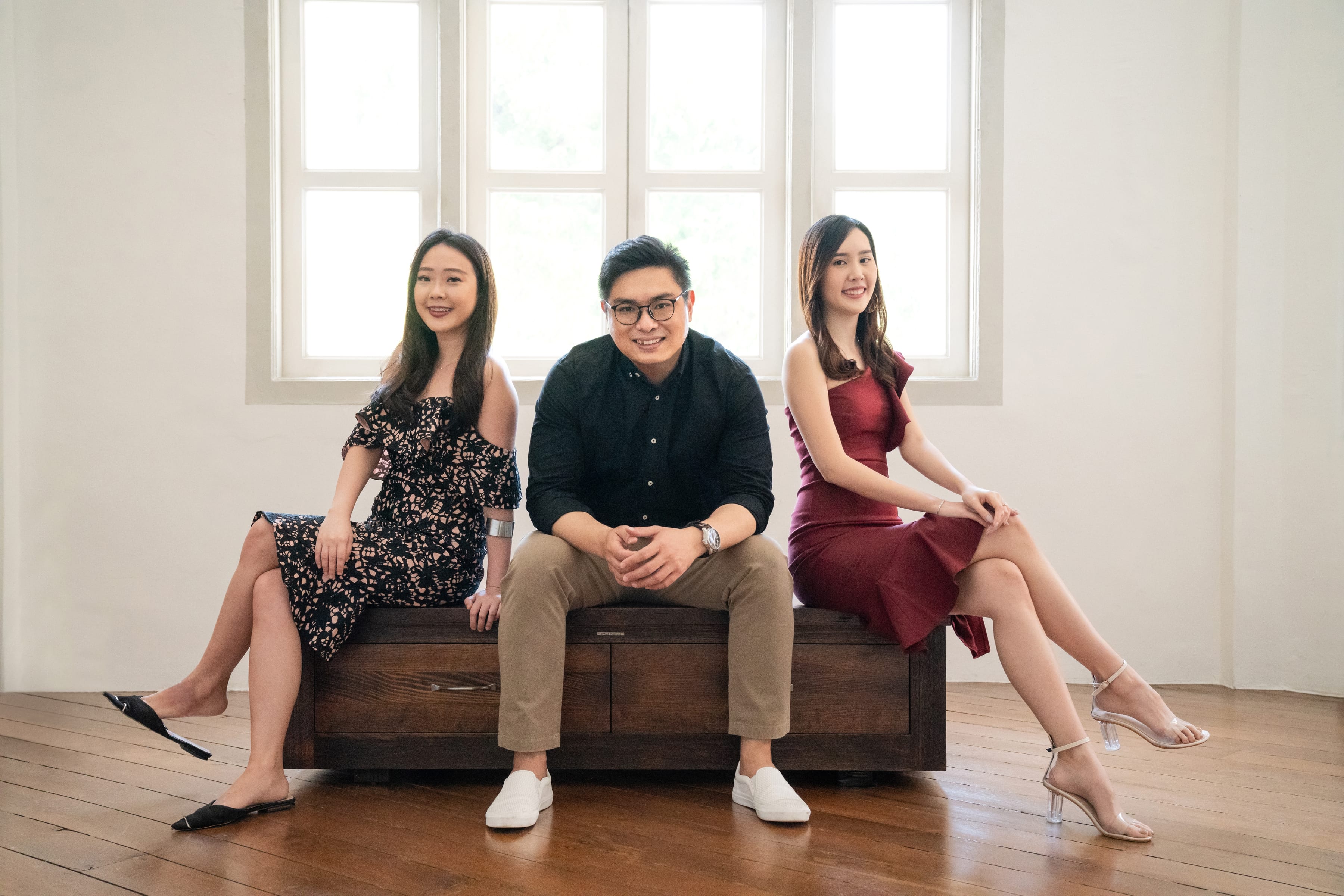 Female and male professionals sitting down in a natural light studio setting during a corporate photoshoot in Singapore, White Room Studio. Credit: White Room Studio Pte Ltd