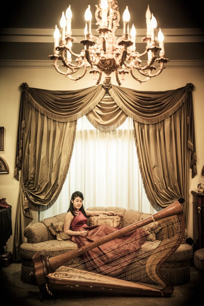 A woman sitting on a sofa with a harp during a professional indoor photo shoot in Singapore