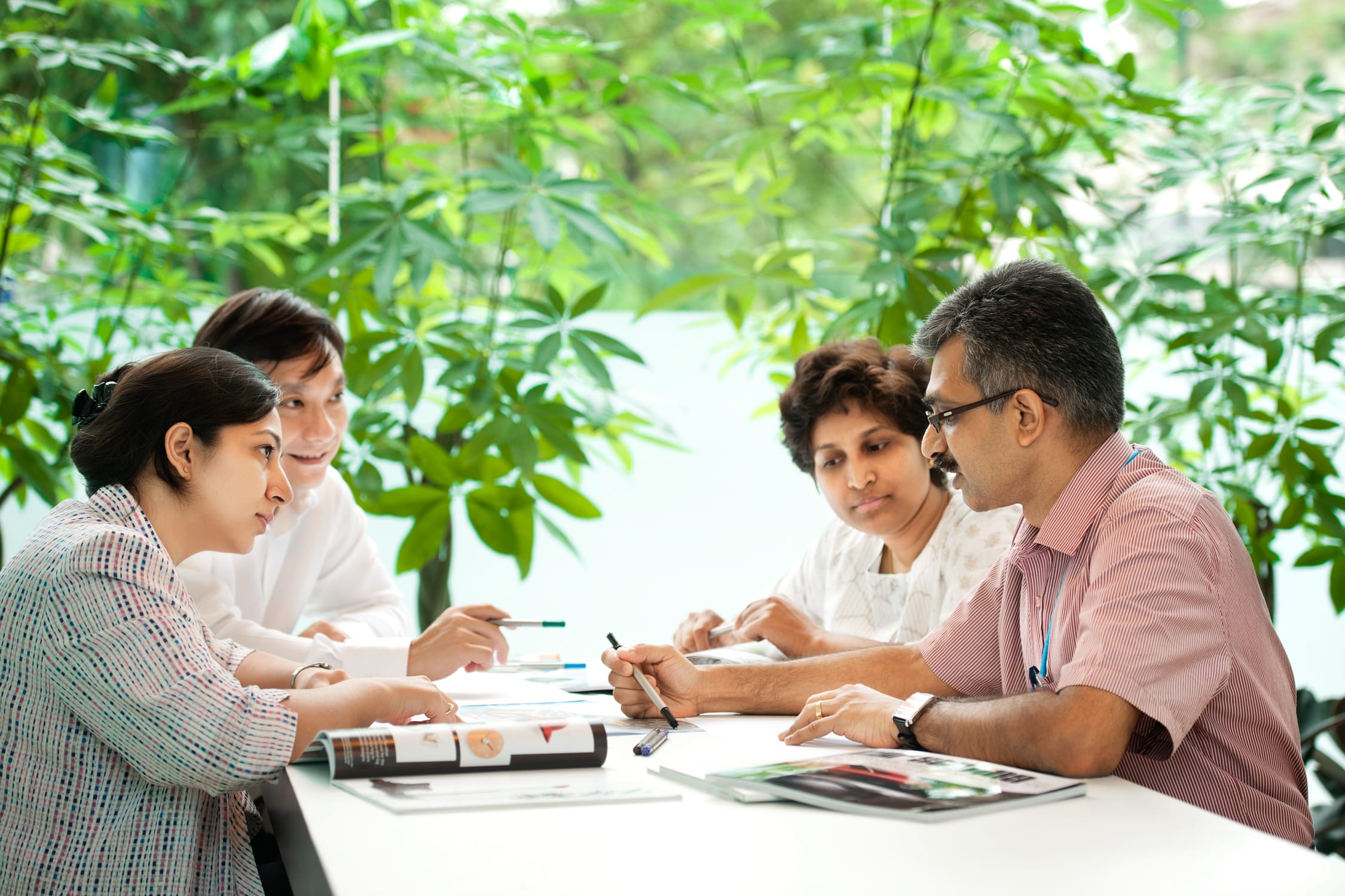 Corporate individuals and business professionals having a meeting in an office setting during a corporate photoshoot in Singapore. Credit: White Room Studio Pte Ltd