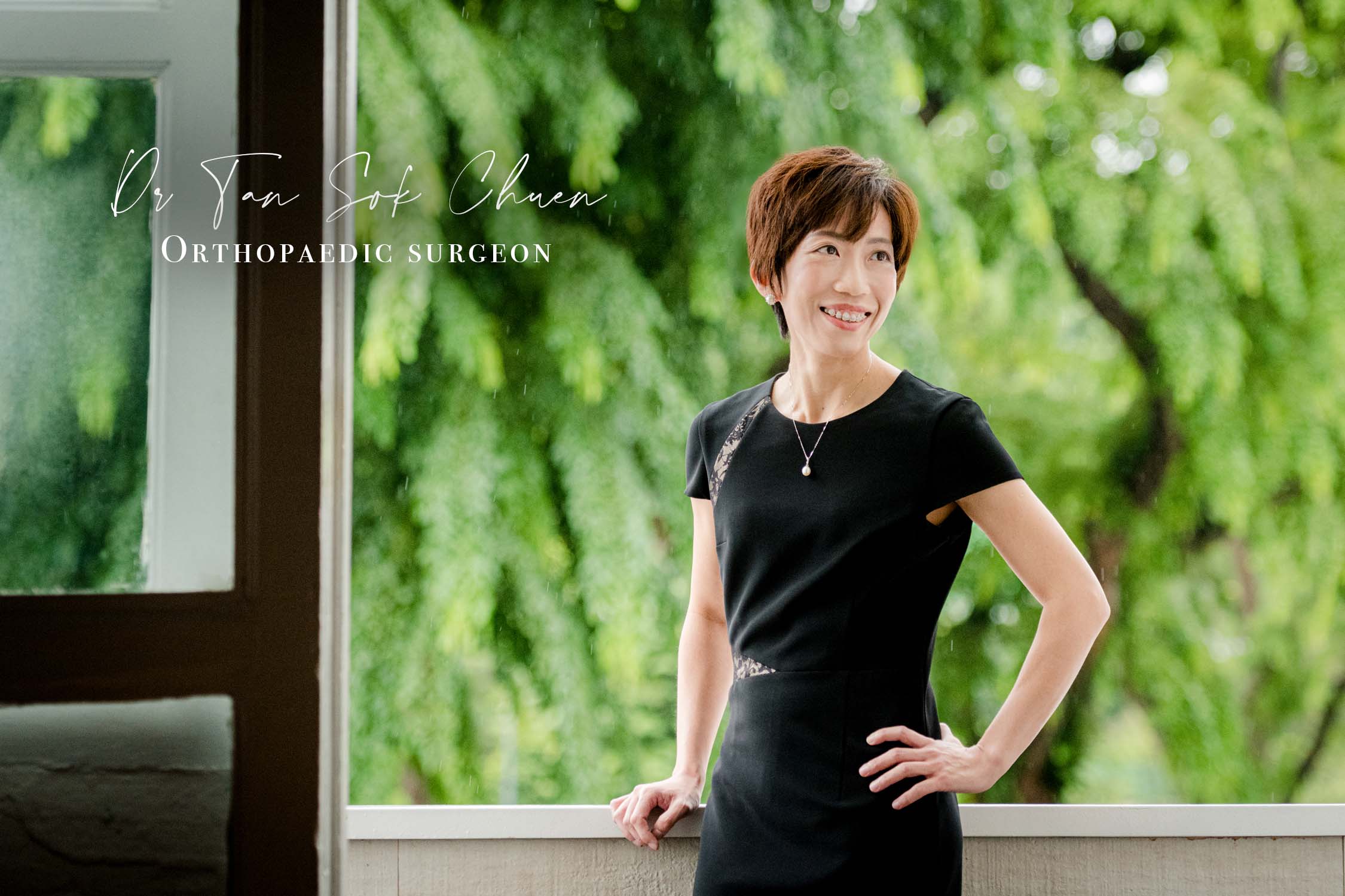 Woman posing for headshot in studio balcony against trees and greenery during a corporate photoshoot in Singapore, White Room Studio. Credit: White Room Studio Pte Ltd