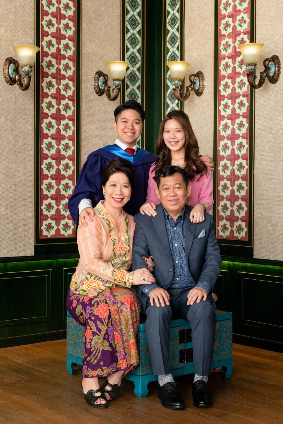 Family with parents and their children with kids in a photography studio setting during a family and graduation photoshoot in Singapore, White Room Studio. Credit: White Room Studio Pte Ltd