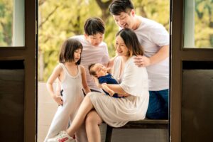 Family with parents and their newborn baby in a photography studio setting during a newborn photoshoot in Singapore, White Room Studio. Credit: White Room Studio Pte Ltd