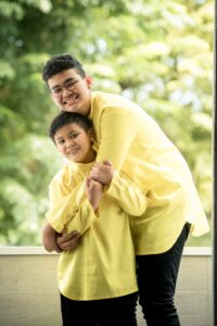 Malay Muslim family with parents and their children with kids ages ranging from toddler to teens in a photography studio setting during a family Hari Raya photoshoot in Singapore, White Room Studio. Credit: White Room Studio Pte Ltd