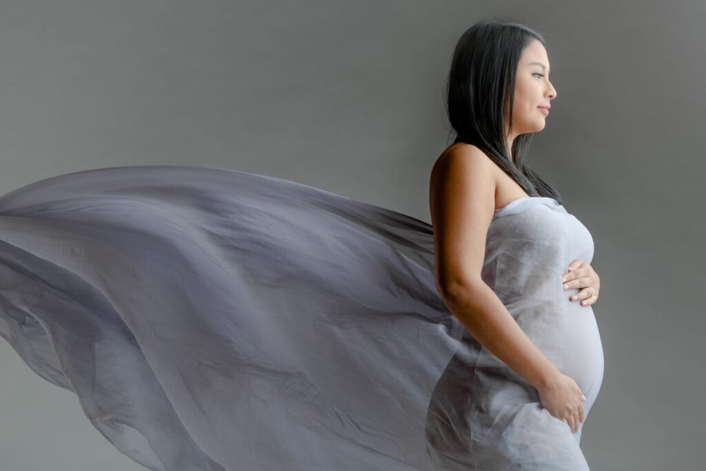 Professional Maternity Photoshoot in Photography Studio, Singapore Pregnant mother, mother-to-be with baby bump in a photography studio setting during a maternity photoshoot in Singapore, White Room Studio. Credit: White Room Studio Pte Ltd