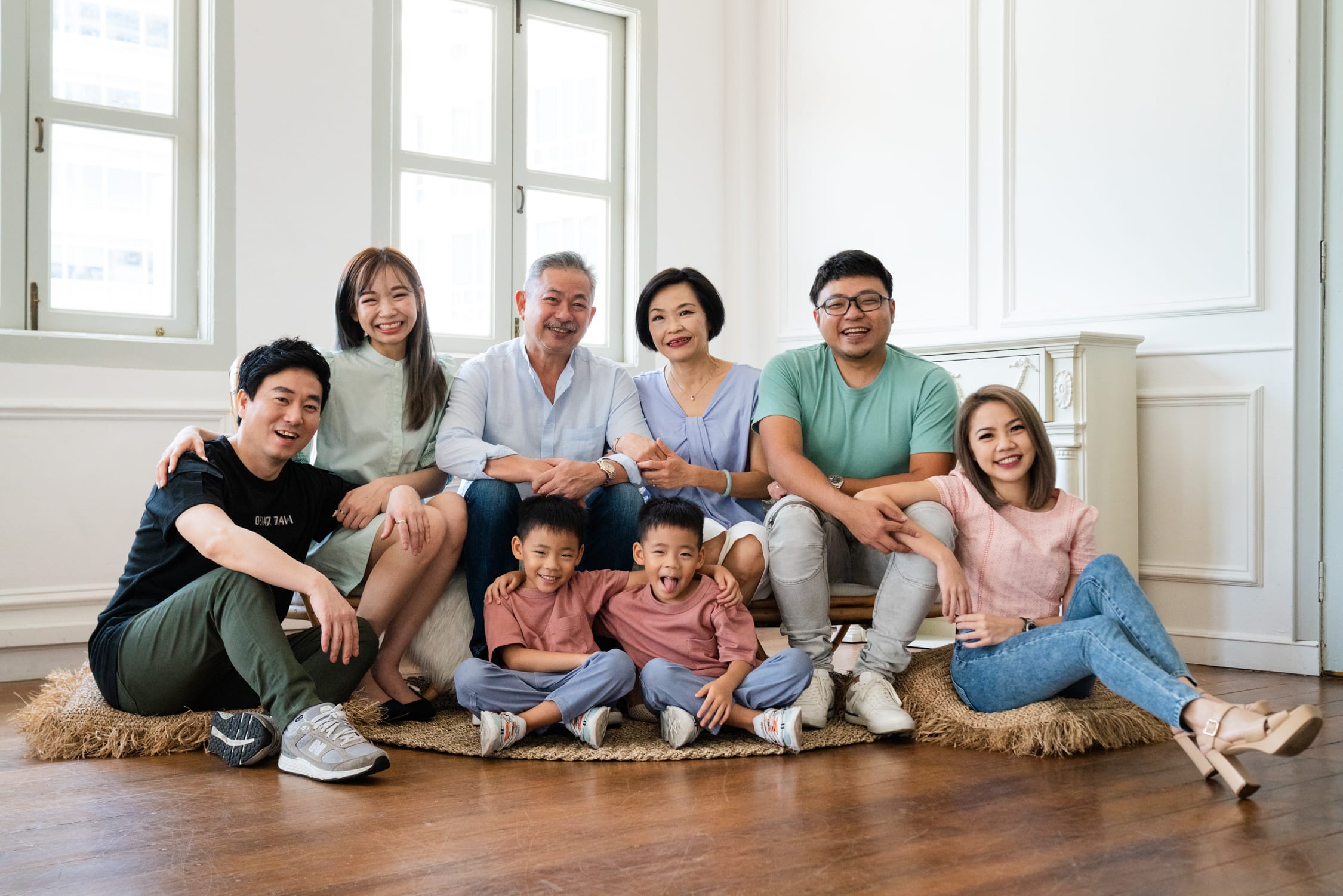 Family with parents and their children with kids ages ranging from toddler to teens in a photography studio setting during a family photoshoot in Singapore, White Room Studio. Credit: White Room Studio Pte Ltd