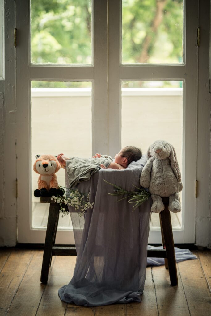 Newborn baby sleeping in a basket with blanket in a photography studio setting at White Room Studio natural light newborn photography studio, 219 River Valley Road, Singapore. Safe gentle newborn photoshoot 2026.