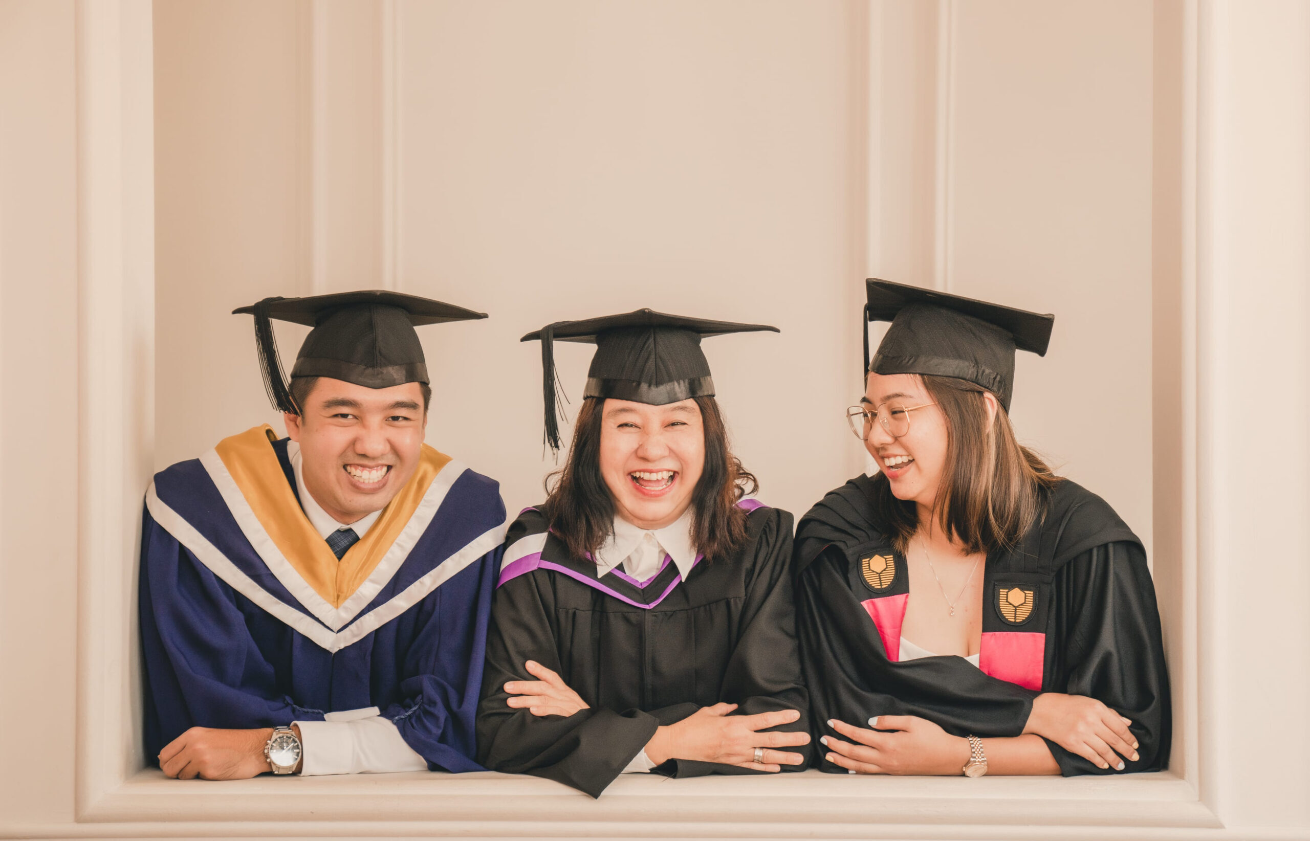 Family with parents and their children in a graduation gown and cap within a photography studio setting during a graduation photoshoot in Singapore, White Room Studio. Credit: White Room Studio Pte Ltd
