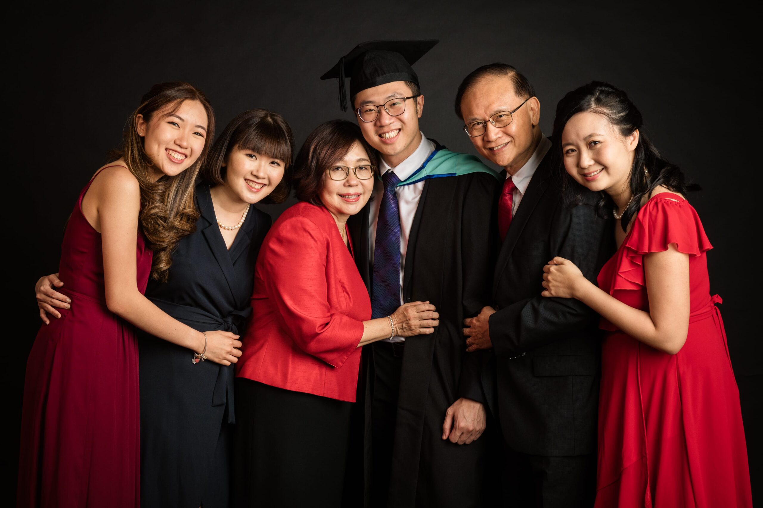 Family with parents and their children with kids ages ranging from toddler to teens in a photography studio setting during a family photoshoot in Singapore, White Room Studio. Credit: White Room Studio Pte Ltd