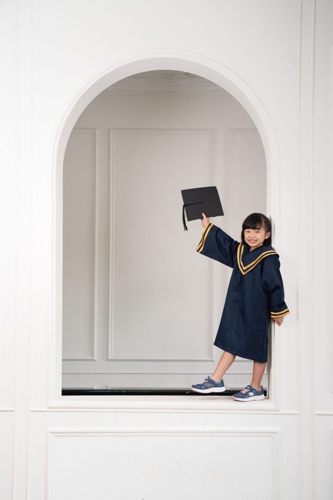 Girl in K2 kindergarten graduation gown and cap during a k2 kindergarten graduation photoshoot in Singapore Credit: White Room Studio