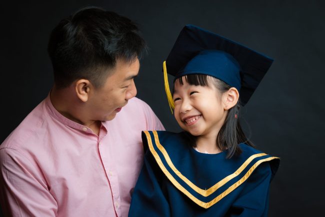 Dad and Girl in K2 kindergarten graduation gown and cap during a k2 kindergarten graduation photoshoot in Singapore Credit: White Room Studio