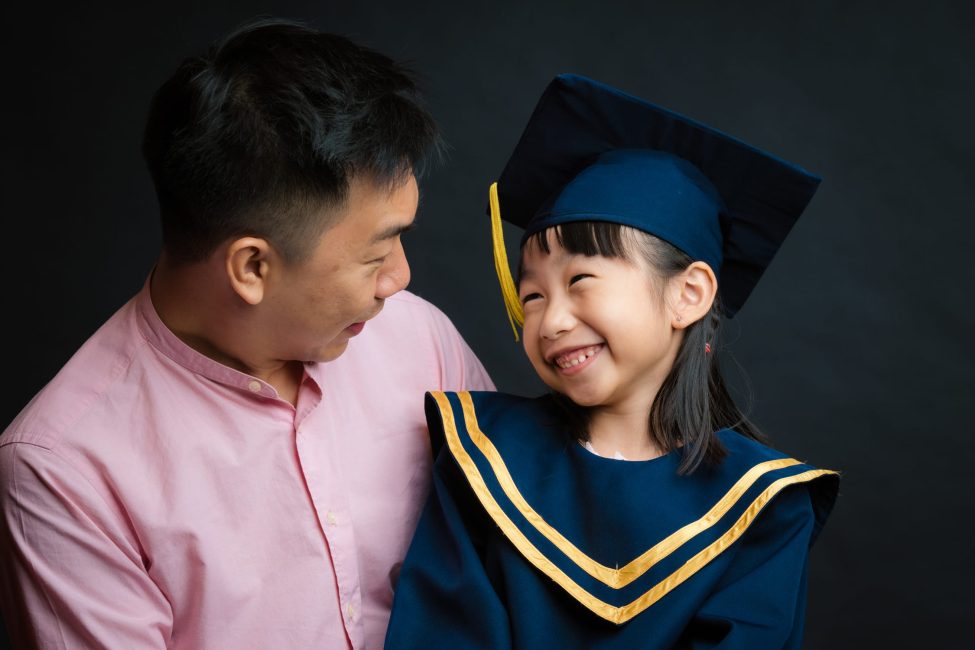 Dad and Girl in K2 kindergarten graduation gown and cap during a k2 kindergarten graduation photoshoot in Singapore Credit: White Room Studio