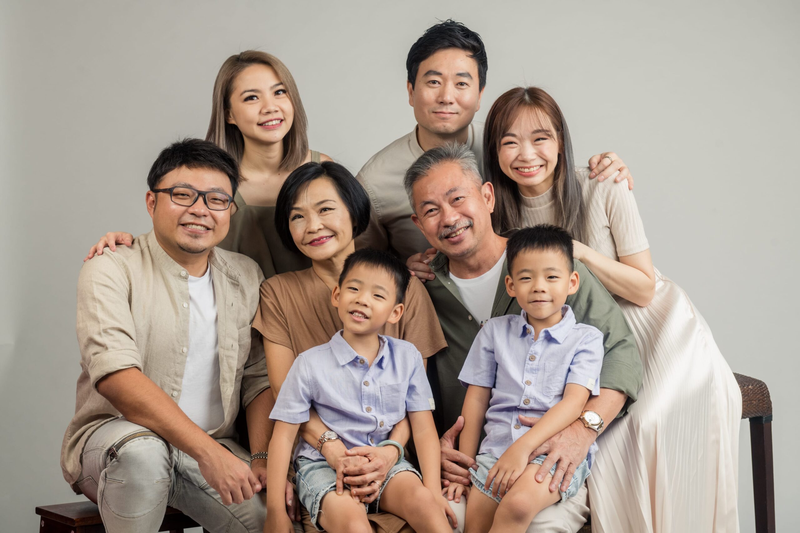 Multi generation family with parents and their children with kids ages ranging from toddler to teens in a photography studio setting during a multi generation family photoshoot in Singapore, White Room Studio. Credit: White Room Studio Pte Ltd