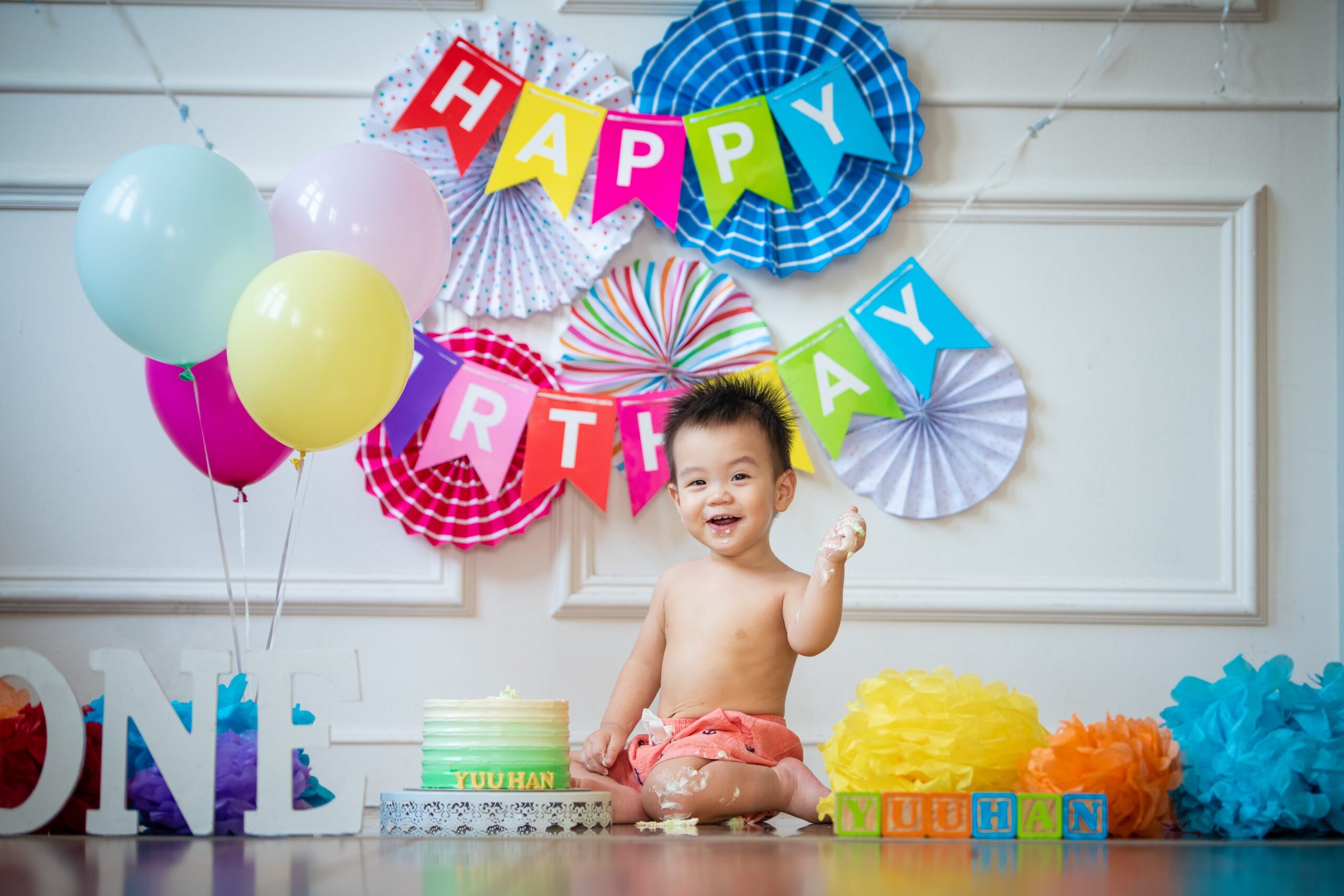 One year old baby celebrating first birthday in a photography studio setting during a cake smash photoshoot in Singapore, White Room Studio. Credit: White Room Studio Pte Ltd