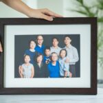 Print in frame of a family with parents and their children with kids ages ranging from toddler to teens in a photography studio setting during a family photoshoot in Singapore, White Room Studio. Credit: White Room Studio Pte Ltd
