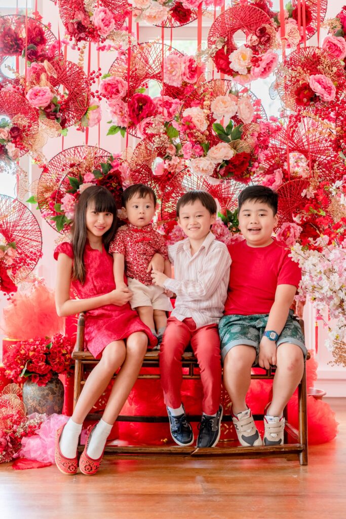 Kids ages ranging from toddler to teens in a photography studio setting during a family Chinese New Year photoshoot in Singapore, White Room Studio. Credit: White Room Studio Pte Ltd