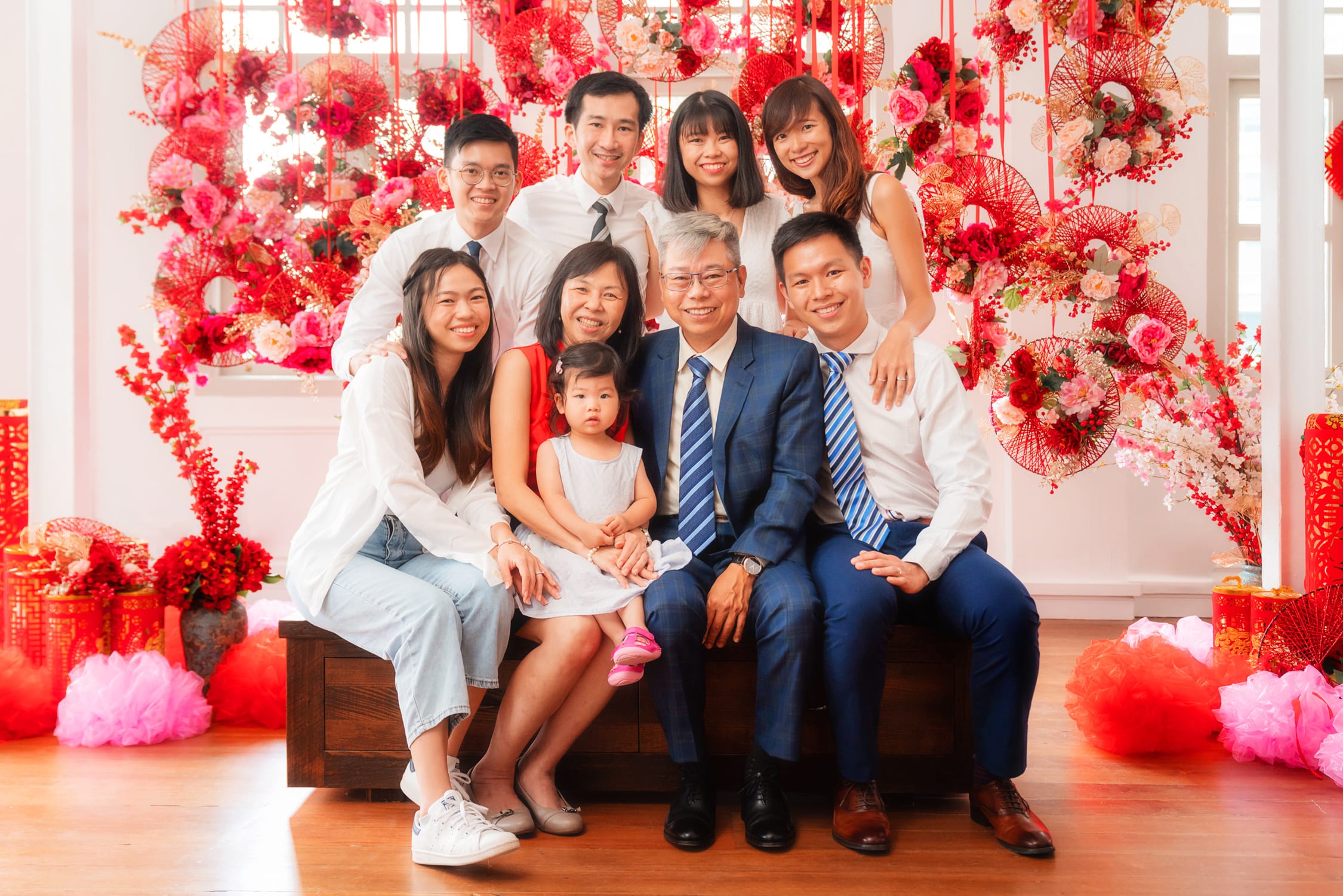Family with parents and their children with kids ages ranging from teens to adults in a photography studio setting during a family Chinese New Year photoshoot in Singapore, White Room Studio. Credit: White Room Studio Pte Ltd