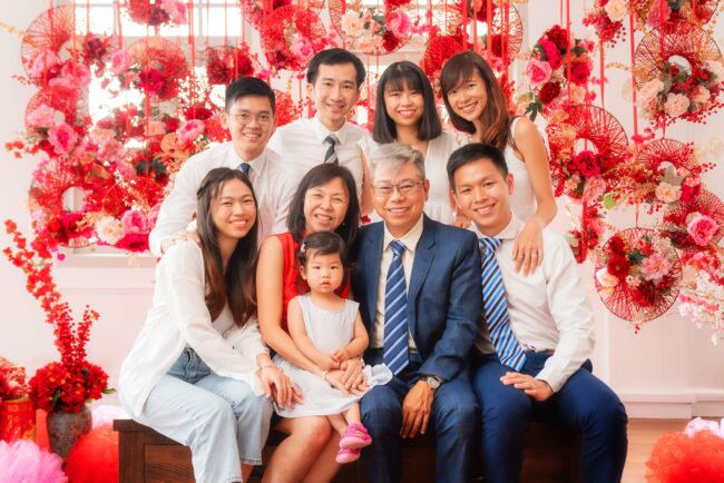 Family with parents and their children with kids ages ranging from teens to adults in a photography studio setting during a family Chinese New Year photoshoot in Singapore, White Room Studio. Credit: White Room Studio Pte Ltd