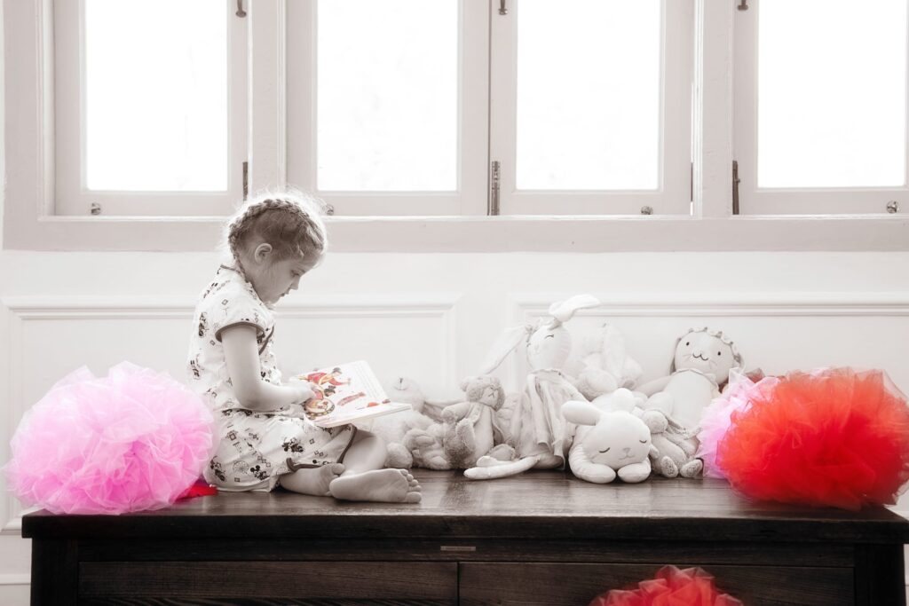 Professional Family and Kids Photoshoot in Photography Studio, Singapore Candid photo of a young girl reading a book in a photography studio setting during a family Chinese New Year photoshoot in Singapore, White Room Studio. Credit: White Room Studio Pte Ltd