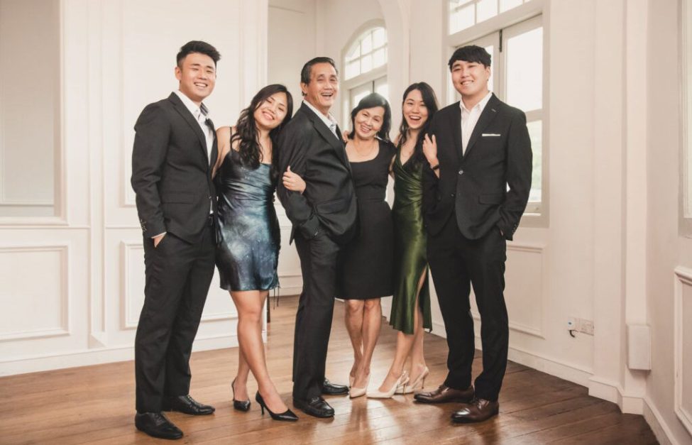 Family with parents and their children with kids ages ranging from toddler to teens in a photography studio setting during a family photoshoot in Singapore, White Room Studio. Credit: White Room Studio Pte Ltd