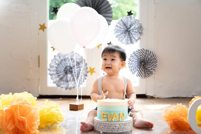 Professional Cake Smash Photoshoot in Photography Studio, Singapore One year old baby in a photography studio setting during a cake smash photoshoot in Singapore, White Room Studio. Credit: White Room Studio Pte Ltd