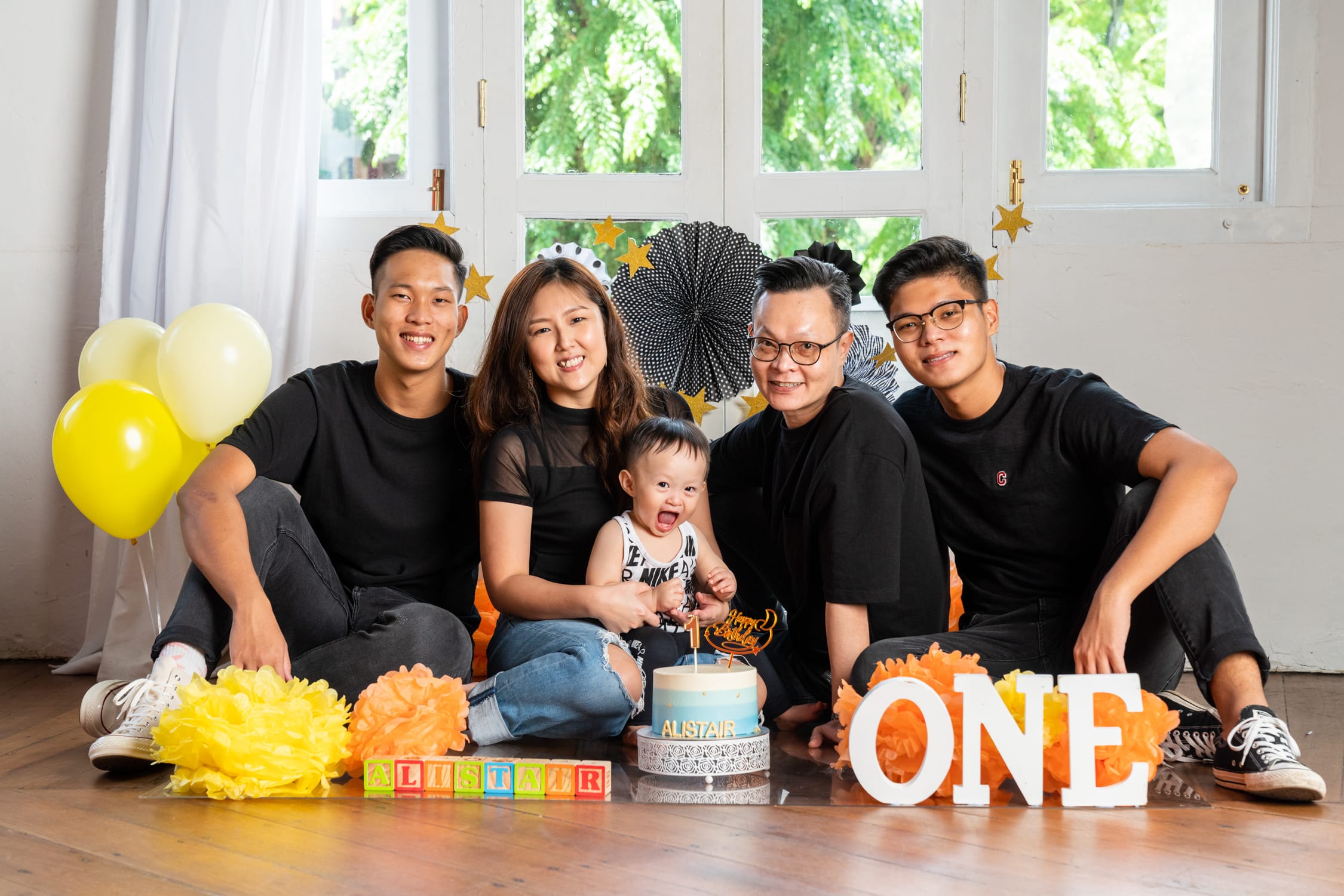 Professional Cake Smash Photoshoot in Photography Studio, Singapore Family with parents and their one year old baby in a photography studio setting during a cake smash photoshoot in Singapore, White Room Studio. Credit: White Room Studio Pte Ltd