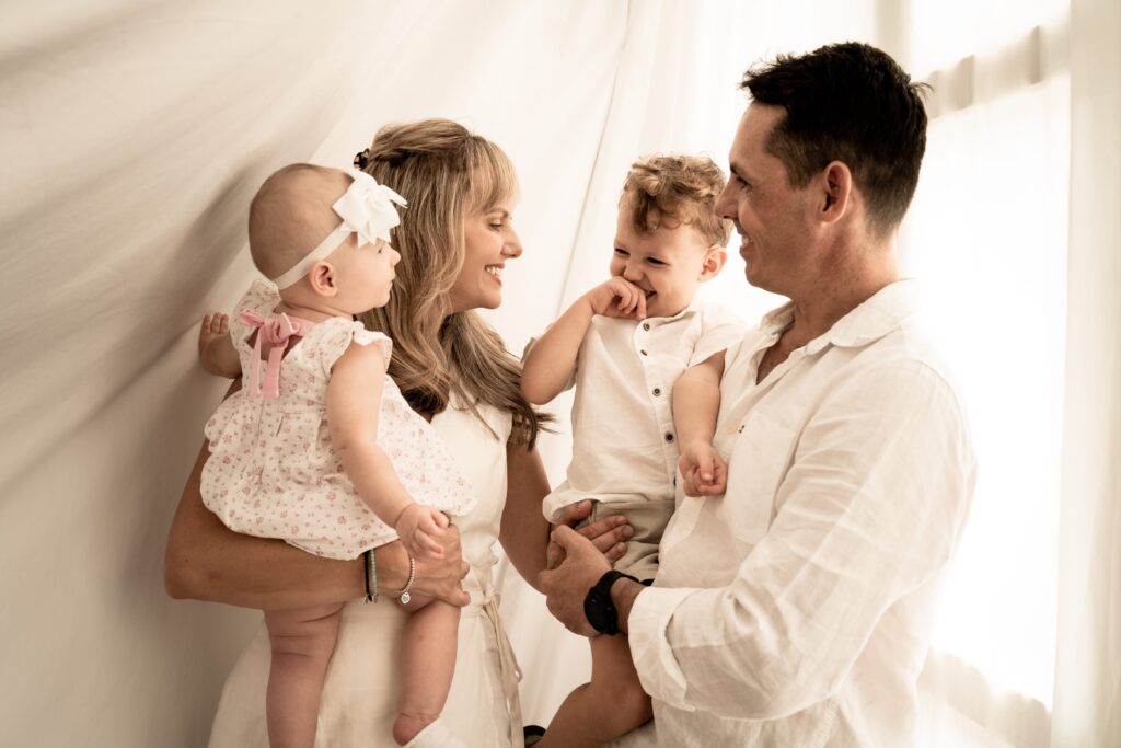 Family with parents and their children with kids in a photography studio setting during a family photoshoot in Singapore, White Room Studio. Credit: White Room Studio Pte Ltd