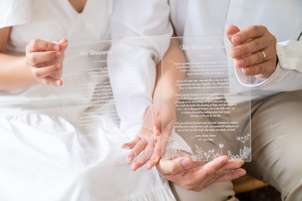 Professional Couple Photoshoot in Photography Studio, Singapore Couple holding acrylic stand with renewal vows in a photography studio setting during a couple photoshoot in Singapore, White Room Studio. Credit: White Room Studio Pte Ltd