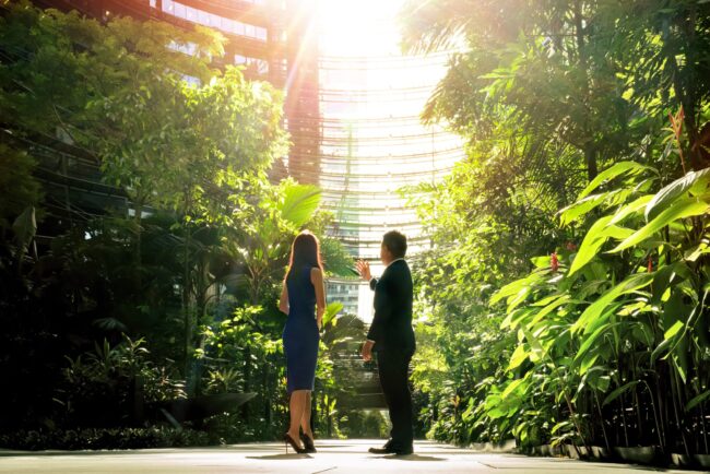 Professional Corporate & Company Photoshoot in Photography Studio, Singapore Two business professionals having a discussion at Marina One during an outdoor corporate photoshoot in Singapore. Credit: White Room Studio Pte Ltd