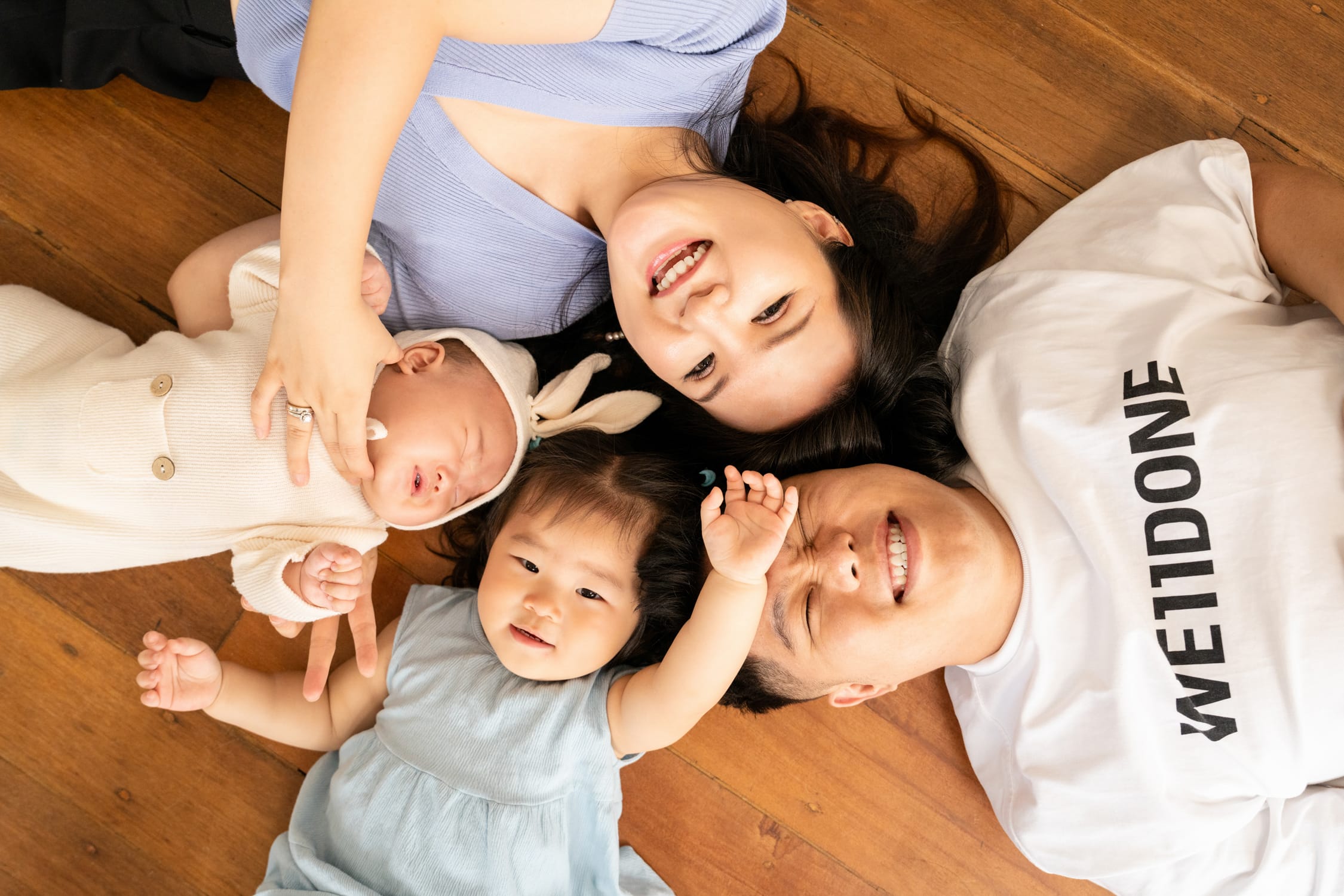 Family with parents and their children with kids ages ranging from newborn to toddler s in a photography studio setting during a family photoshoot in Singapore, White Room Studio. Credit: White Room Studio Pte Ltd