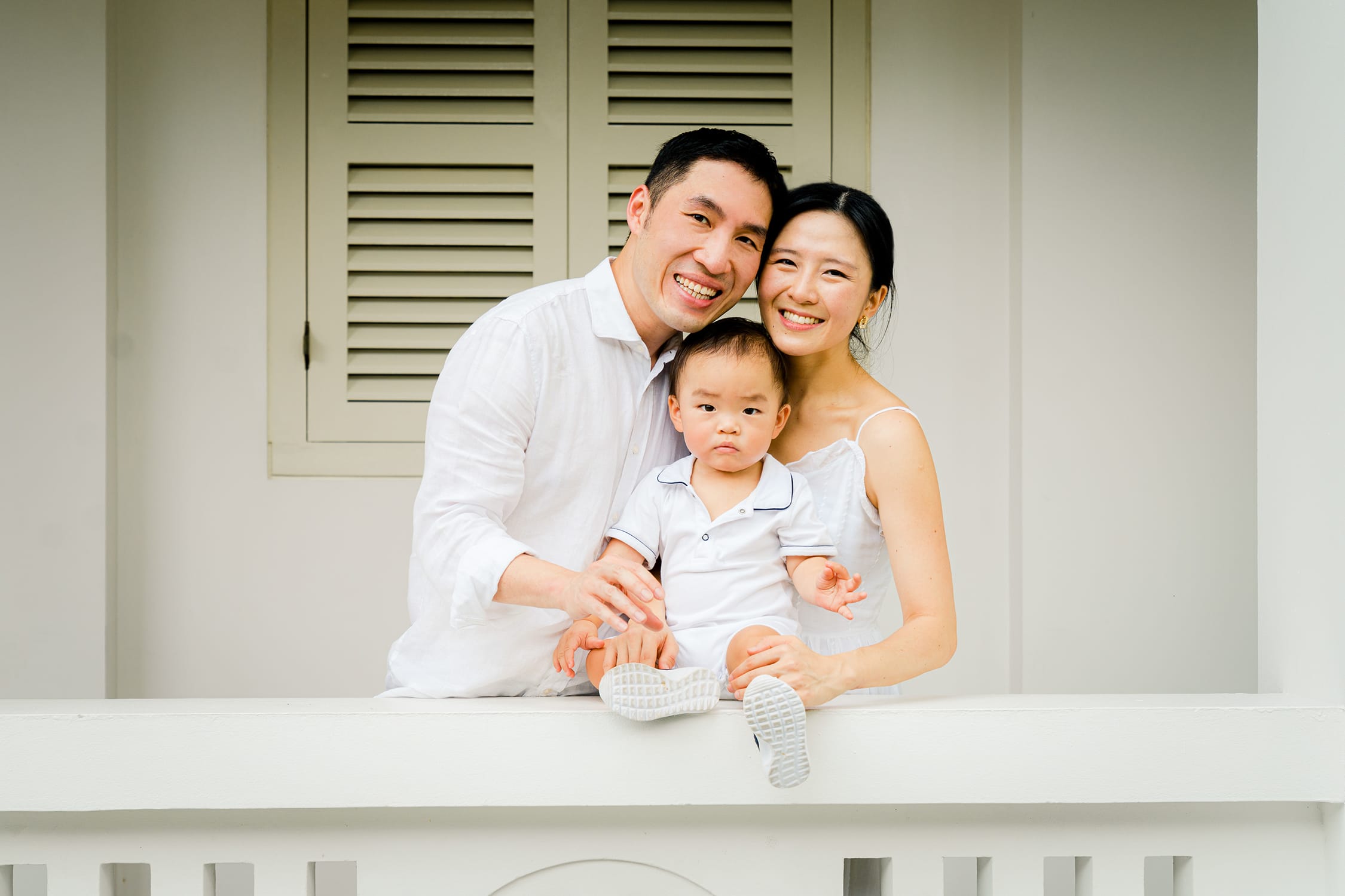 Family with mother and father carrying toddler son during an outdoor family photoshoot in Capella Hotel Singapore. Credit: White Room Studio Pte Ltd