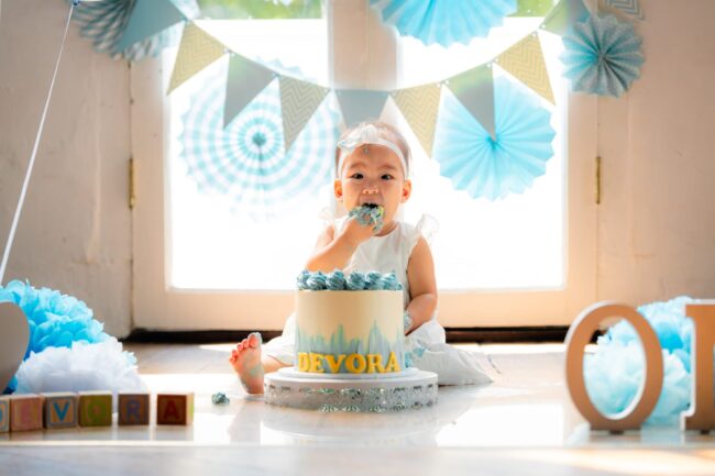 One year old baby in a photography studio setting during a cake smash photoshoot in Singapore, White Room Studio. Credit: White Room Studio Pte Ltd