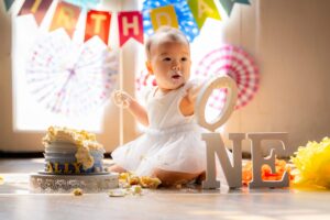 One year old baby in a photography studio setting during a cake smash photoshoot in Singapore, White Room Studio. Credit: White Room Studio Pte Ltd