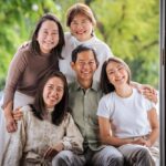 Family photoshoot studio photography of family of five huddled together photographed White Room Studio natural light family photography studio, 219 River Valley Road, Singapore. Natural light family portrait 2026.