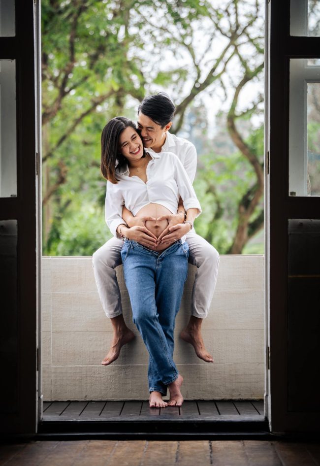 Maternity Photoshoot of husband hugging pregnant wife in photo studio at White Room Studio, 219 River Valley Road Singapore