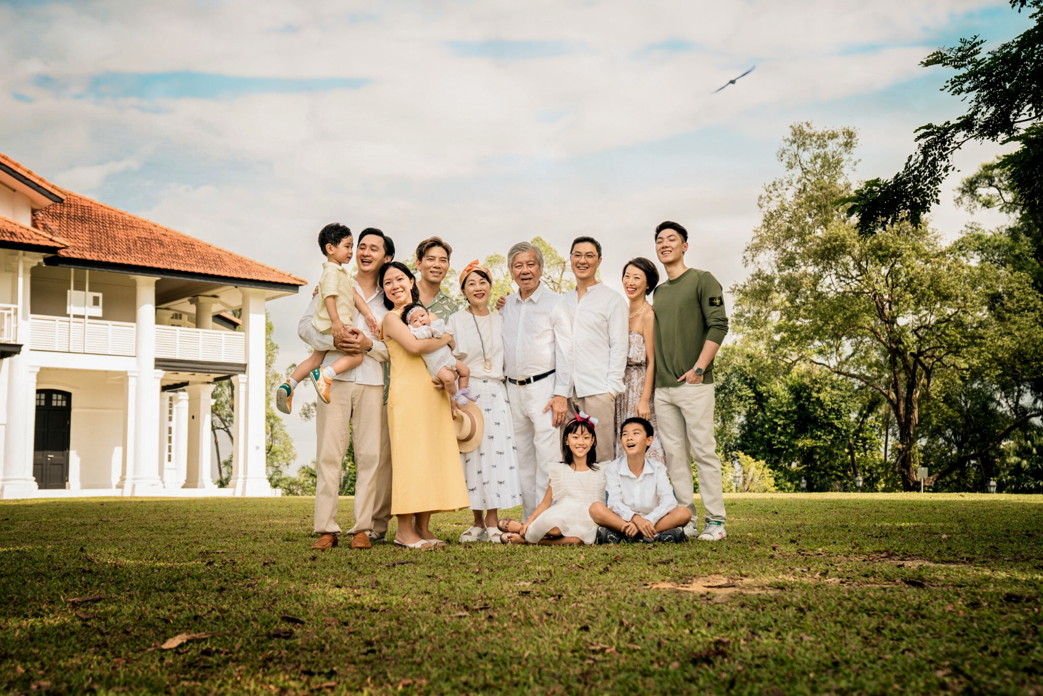 Professional Family & Multi Generation Photoshoot in Photography Studio, Singapore Multi generation family with grandparents and parents hugging their children during a family outdoor photoshoot in Singapore, Botanic Gardens. Credit: White Room Studio Pte Ltd