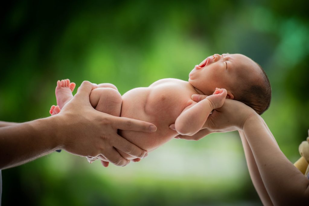 parents holding on to newborn at White Room Studio natural light newborn photography studio, 219 River Valley Road, Singapore. Safe gentle newborn photoshoot 2026.