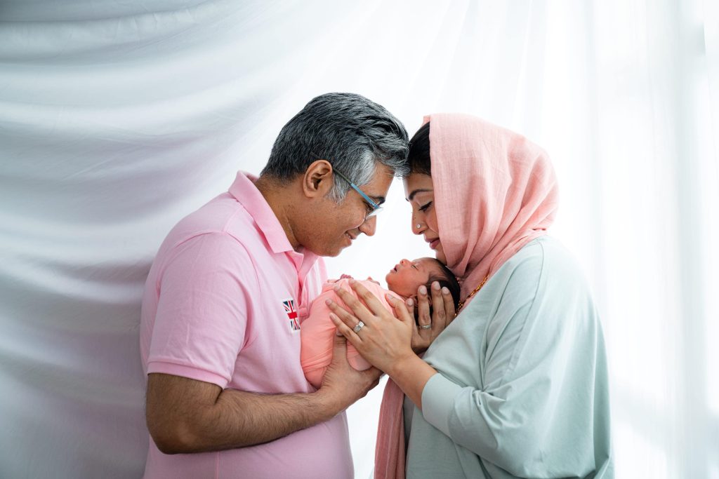Family with their newborn baby during a newborn photoshoot at White Room Studio, Singapore