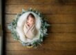 Family with parents and their newborn baby in a photography studio setting during a newborn photoshoot in Singapore, White Room Studio. Credit: White Room Studio Pte Ltd