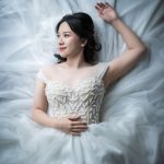 Bridal Photography of bride laying down on her dress in natural light photo studio at White Room Studio, 219 River Valley Road Singapore