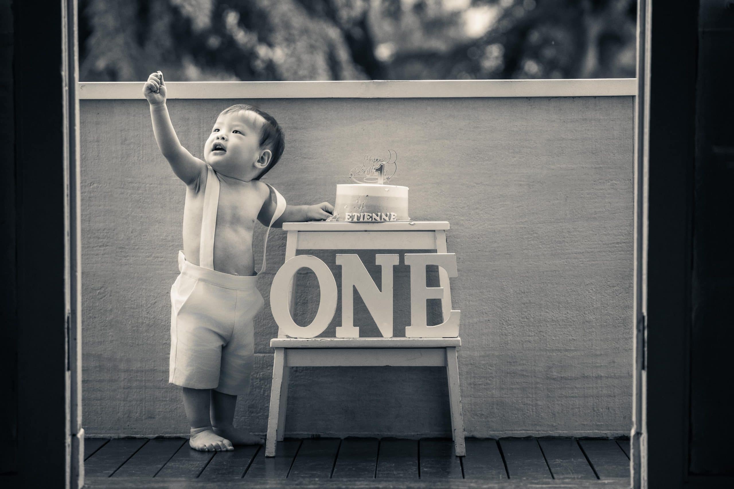 Cake smash photoshoot of a 1 year old boy in natural light Christmas photo studio setup at White Room Studio, 219 River Valley Road Singapore